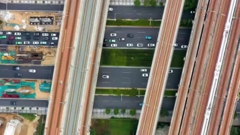 the panoramic view electric urban rail train rides on the railway bridge overpass the highway with car vehicles