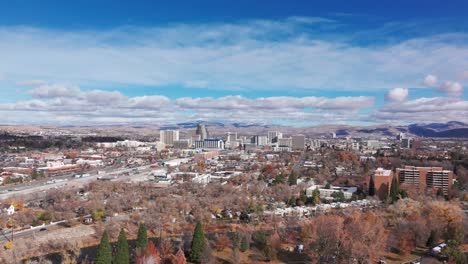 drone shot flying towards downtown reno, nevada on a partly cloudy day