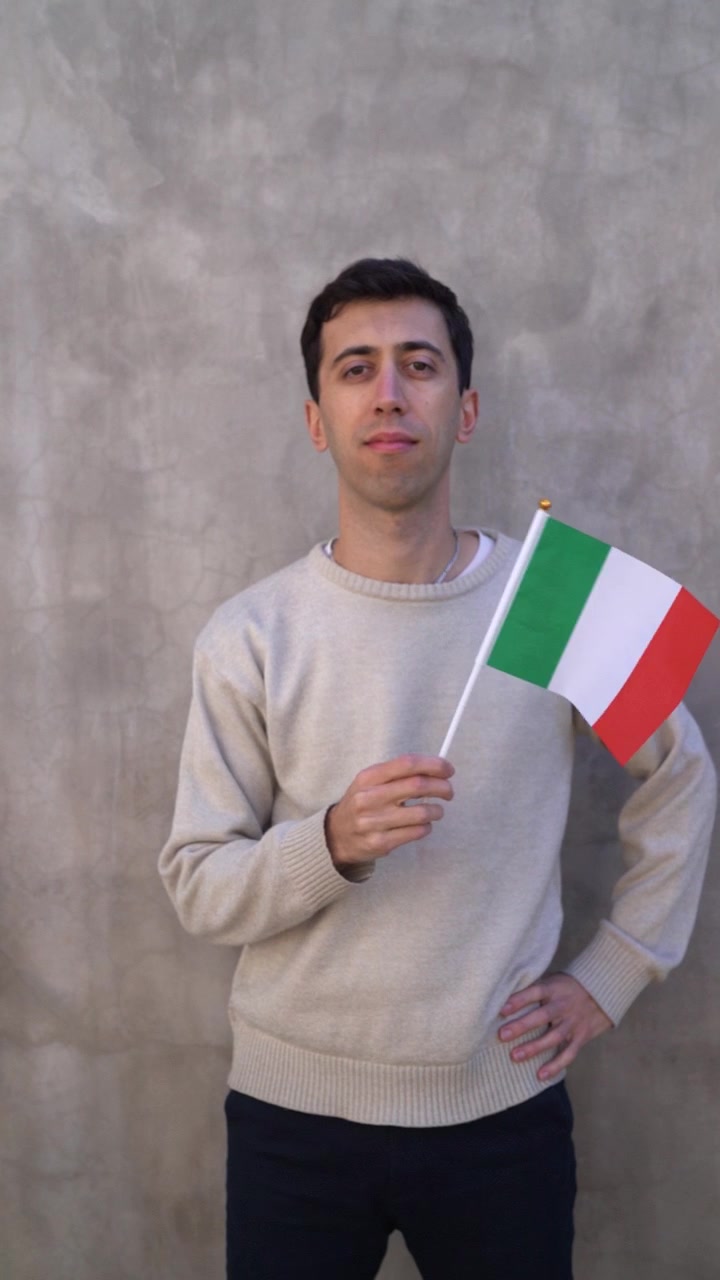Hombre adulto ondeando la bandera de Italia. Cámara lenta. Toma vertical.