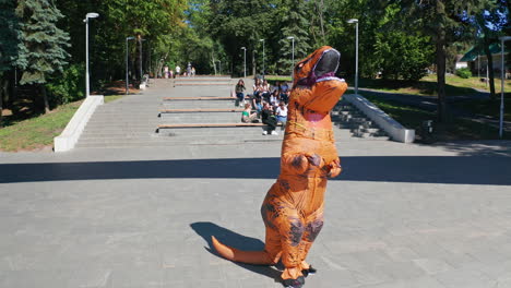 person in a t-rex costume in a park