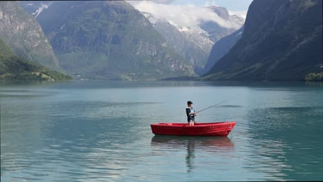 la mujer en el barco atrapa un pez en el giro en noruega.