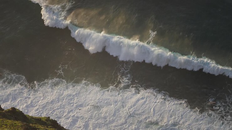 Large powerful wave breaking on rugged island shore of Madeira, slow motion