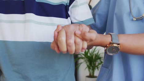 animación de las manos de una doctora biracial y un anciano caucásico durante la recuperación
