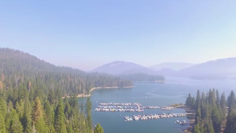 Sobrevuelo-Aéreo-Ascendente-De-Un-Pequeño-Puerto-Deportivo-Con-Barcos-Atracados-En-El-Lago-Shaver-En-Las-Montañas-De-Sierra-Nevada-De-California