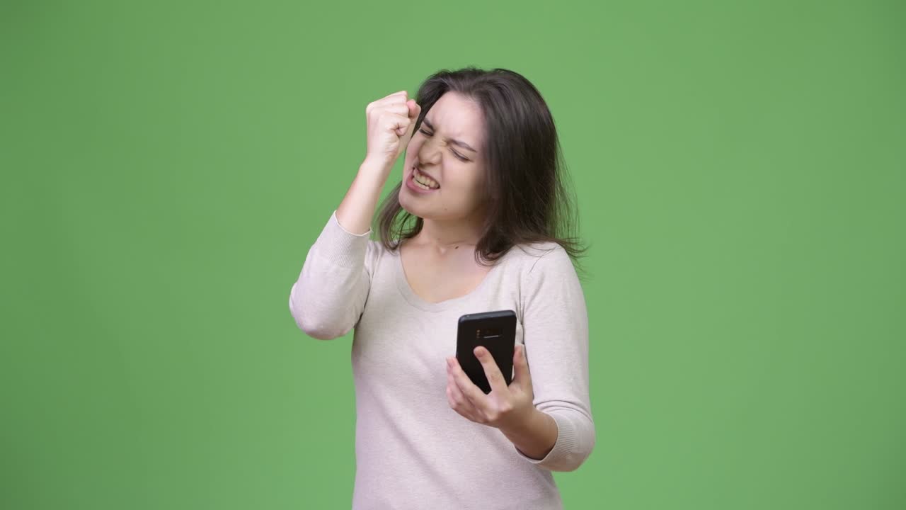 Young beautiful woman using phone and getting good news