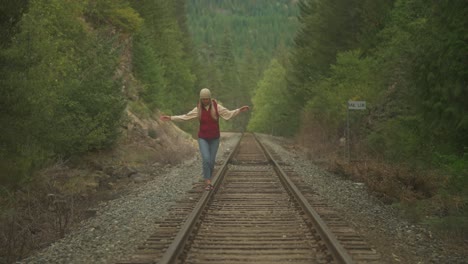 free spirit hipster woman balancing on abandoned railway steel track