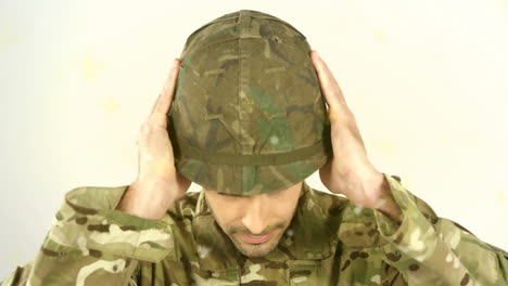 adjusting helmet with both hands, person in camouflage uniform outdoors
