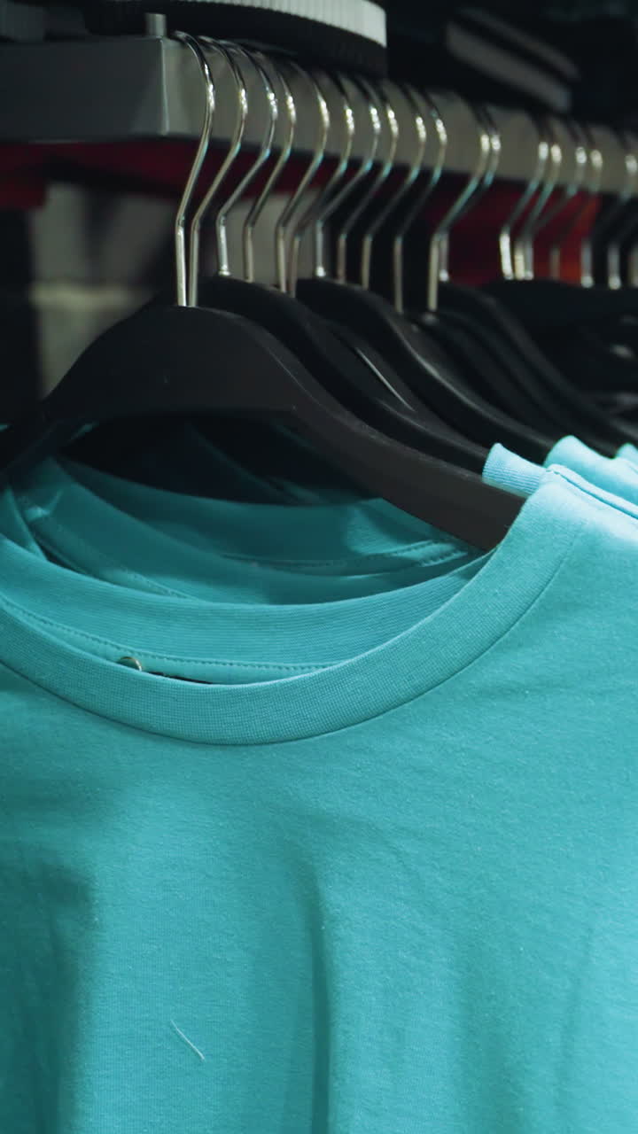 A clothing store displaying a close-up of blue and white clothes neatly hung on hanger.This video highlights the organized display and variety of apparel in a modern retail environment