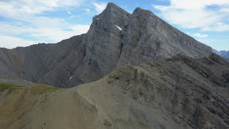 Rocky-alpine-peaks,-scree-slopes,-aerial-view-of-angled-bedding-plane