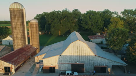 antena pasando de cerca sobre la parte superior del granero revelando silos de grano en la granja, 4k