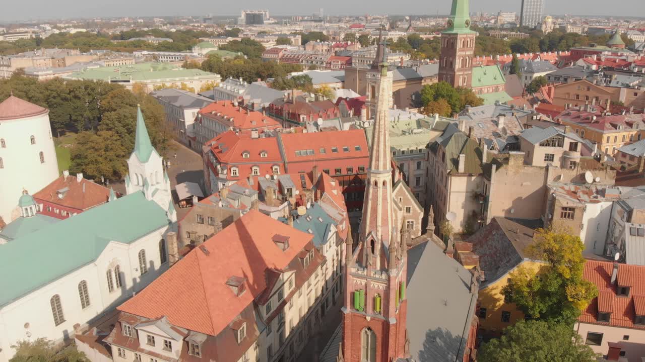 toma aérea sobre la iglesia anglicana de st saviors en riga, letonia, inclinación hacia arriba para revelar el paisaje urbano de la capital, día soleado