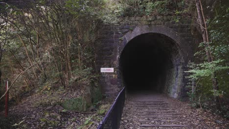 abandoned dark tunnel through mountains of takedao abandoned rail hike, japan