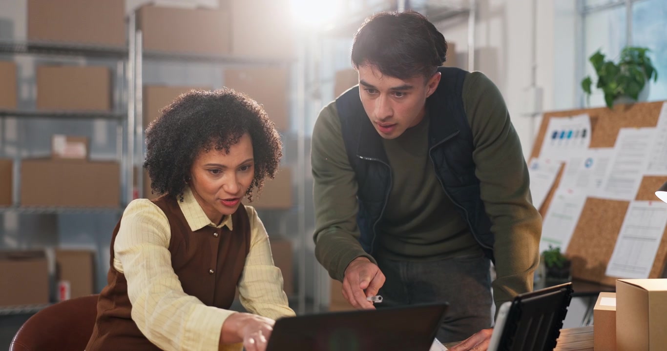 Two Colleagues Collaborating on a Project in a Warehouse Office