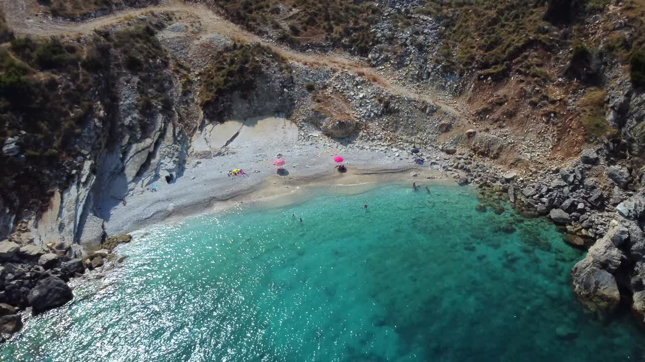 Drone shot of the Albanian coast in the Mediterranean sea - drone is reversing from a lonely beach