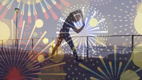 iconos de fuegos artificiales contra afroamericanos hombre en forma realizando ejercicios de estiramiento en el paseo marítimo