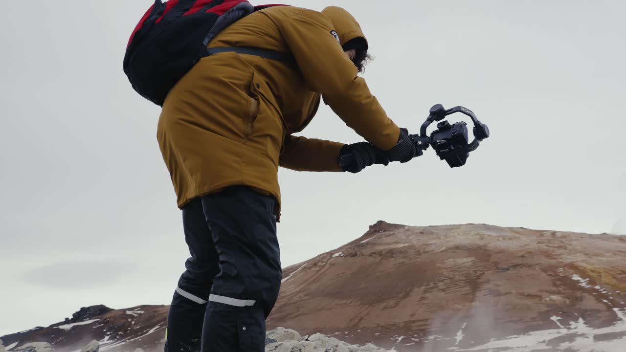 아이슬란드 의 증기  ⁇ 트 에서 나오는 연기를 촬영 하는 비디오 촬영자 의 낮은 각도 촬영