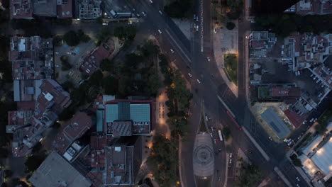 Aerial-birds-eye-overhead-top-down-panning-view-of-traffic-in-streets-of-downtown.-Flying-drone-in-evening,-low-light.-Mexico-city,-Mexico.