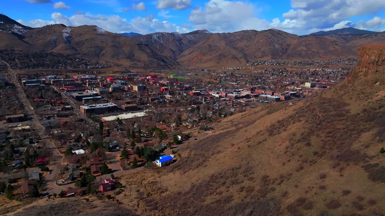 Winter morning front range Lookout North Table Mountain downtown Golden Colorado aerial drone Denver Suburbs neighborhood city Coors Beer sunny blue sky snow on hills forward pan up motion