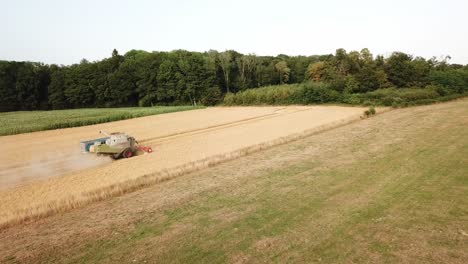 "a cinematic 4k drone shot of a combine harvester and a tractor harvesting a field in france, showcasing agriculture with an epic view and dramatic dust