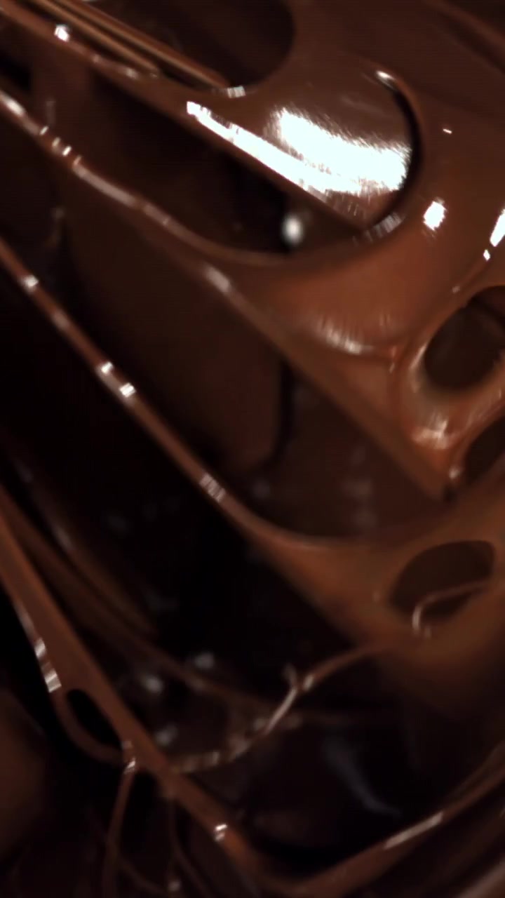 Primo piano di frusta che mescola cioccolato fondente fuso e cremoso