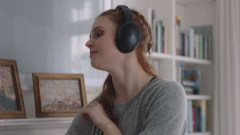 mujer feliz bailando en casa divirtiéndose escuchando música usando auriculares disfrutando de la celebración del fin de semana con movimientos de baile divertidos