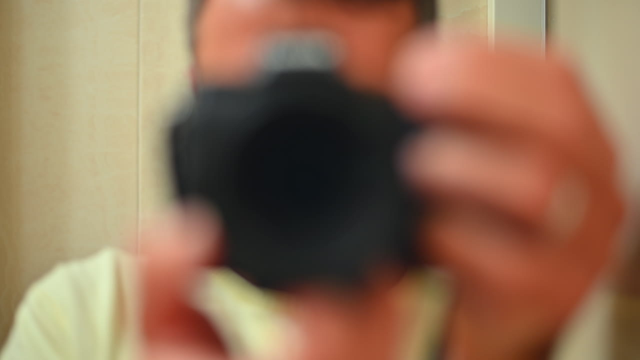 Chisinau, Moldova - January 3, 2022: A person takes a close-up photo of themselves with a camera in a warm and inviting indoor environment. The atmosphere is relaxed and personal