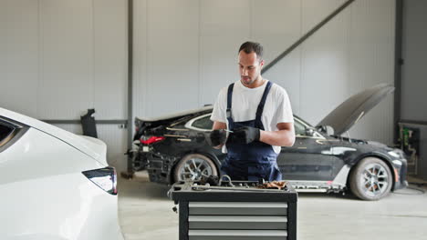 mecánico de automóviles trabajando en coches en un garaje