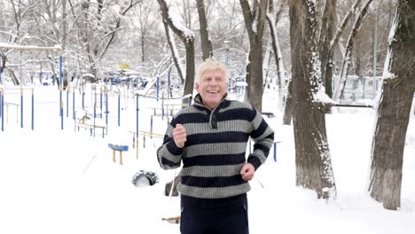 an elderly european man does a morning outdoor warm-up in the winter, running on the spot. healthy life concept. 60 fps