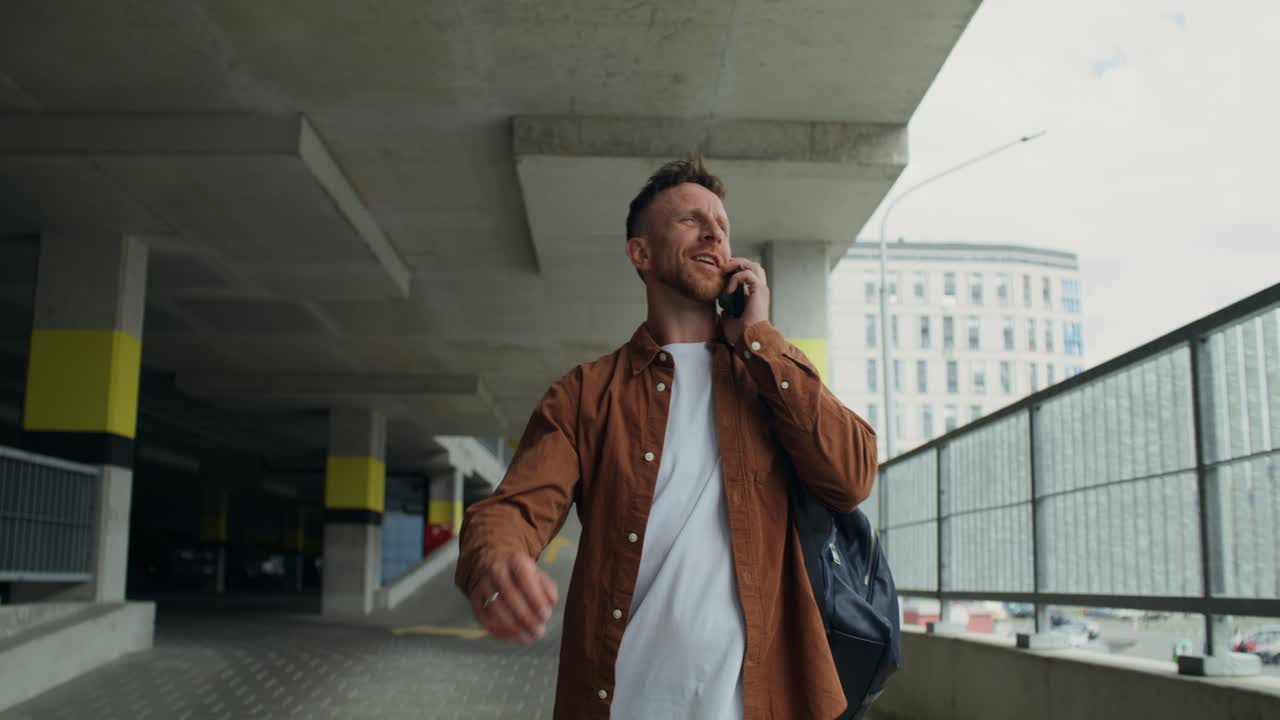 Uomo che parla al cellulare in un parcheggio