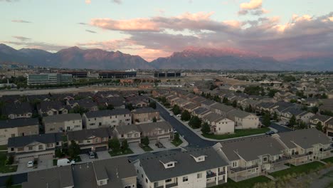 Vista-Panorámica-Aérea-Deslizante-De-Un-Barrio-Suburbano-Al-Atardecer-En-Un-Valle-Bajo-Las-Montañas