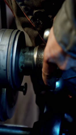 industry manufacturing metalwork. close up of hand heavy industrial worker is working on metal work factory process by performing mechanical turning operation at machine. vertical video