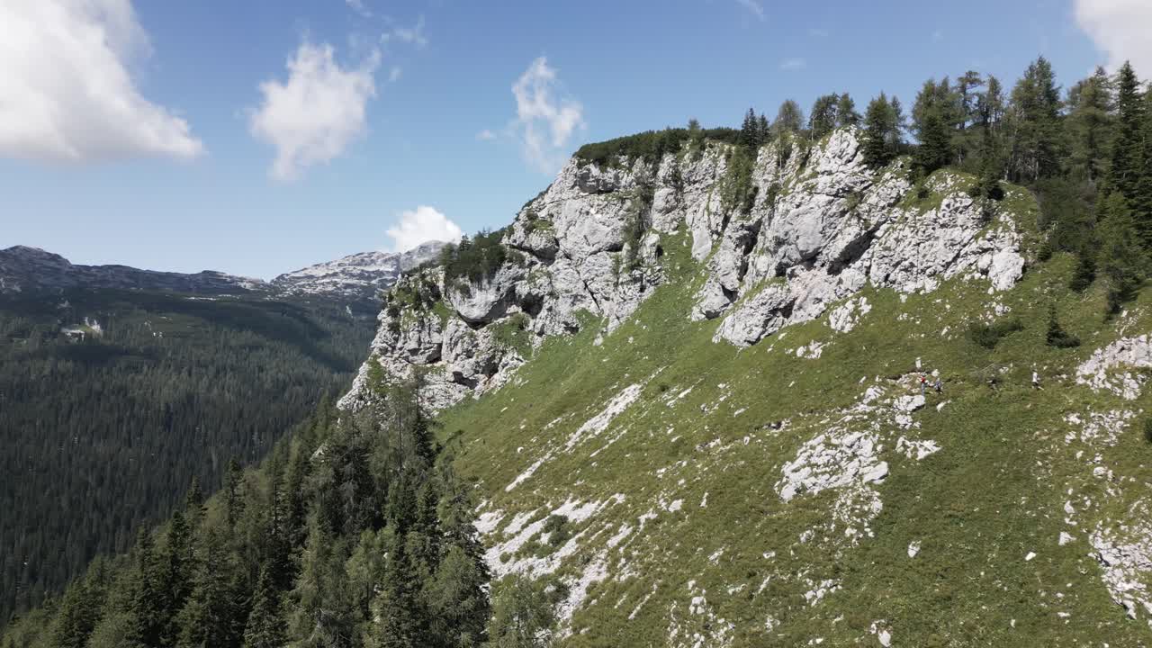 personas caminando por un pequeño sendero en una gran montaña con una vista