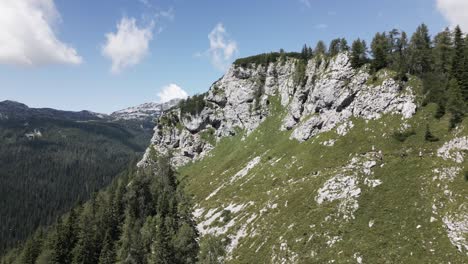 people hiking a small path on a big mountain with a view