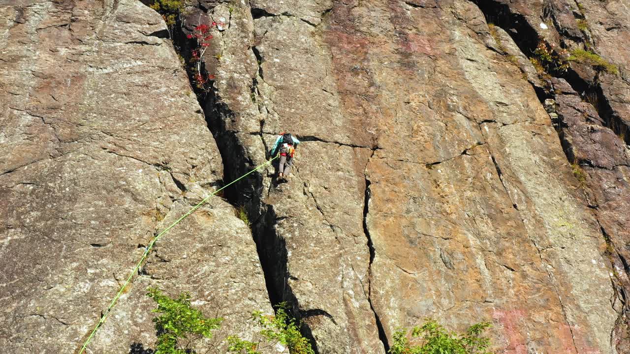 imágenes aéreas que se inclinan más allá de un escalador solitario en un acantilado en maine