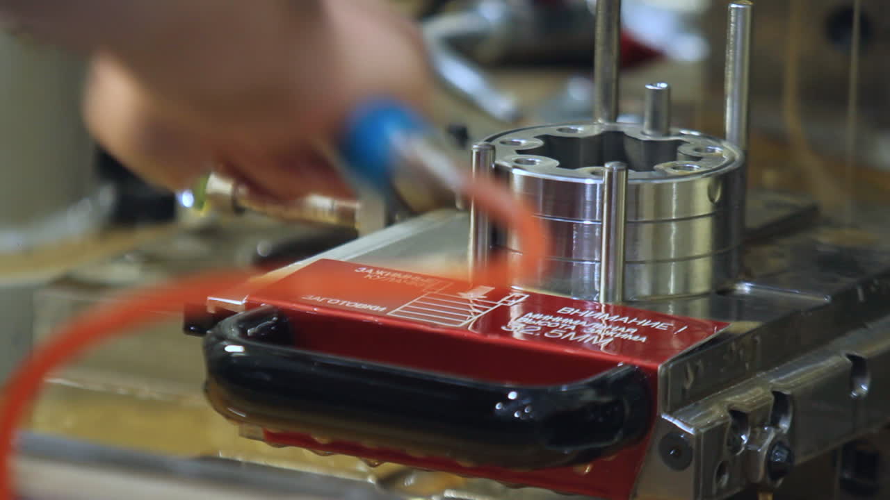 trabajador de la fábrica lavando lubricante de piezas metálicas con una corriente de agua