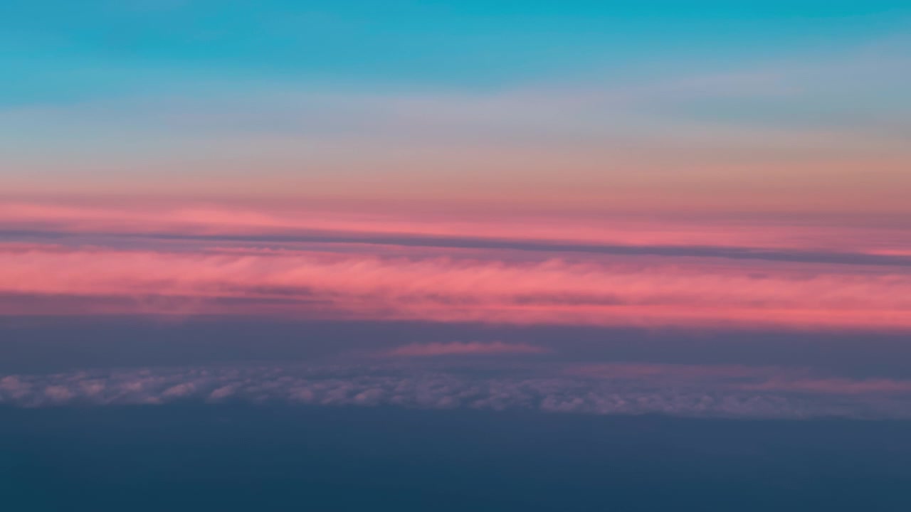 Layered pink and lavender sky bands above distant clouds at altitude