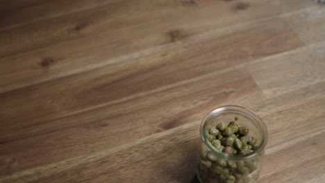 disparo cercano medio de la alcaparra sentada en un pequeño frasco de vidrio