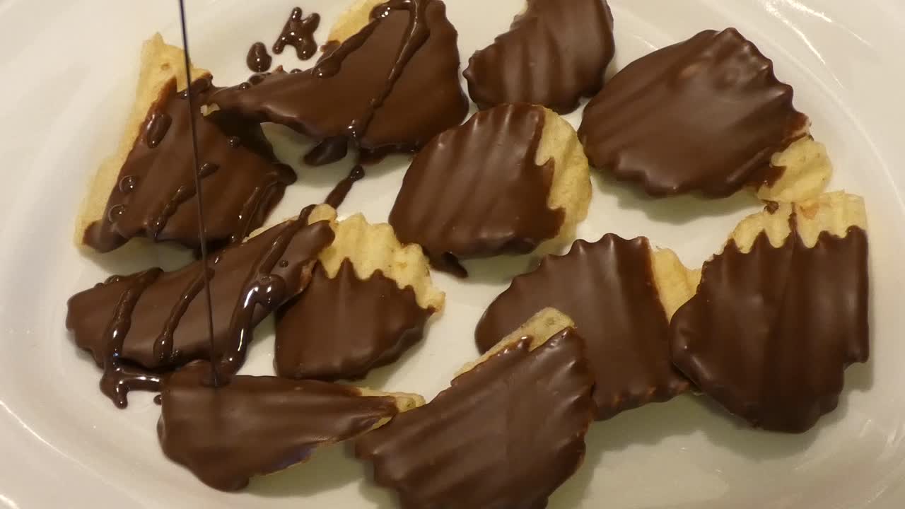 Dark chocolate is drizzled over chocolate-covered potato chips.