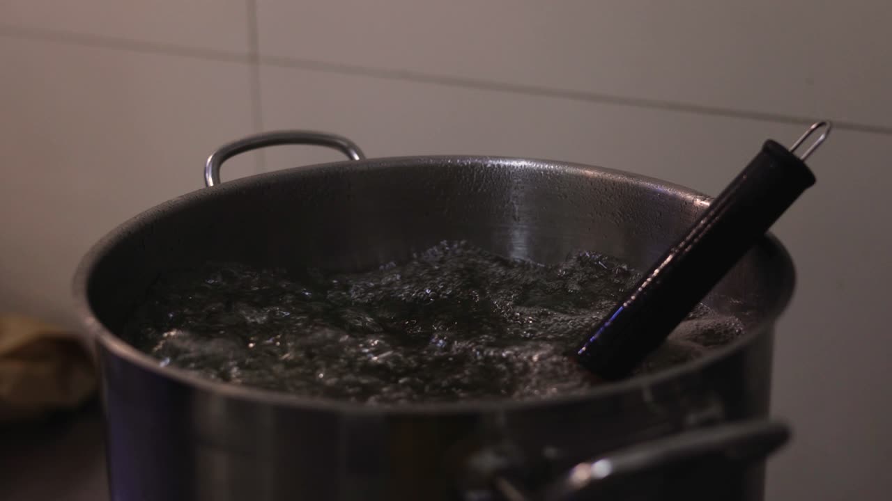 Lo sciroppo bolle nella pentola, rilasciando bolle a causa del calore, preparato per il dolce in pasticceria.
