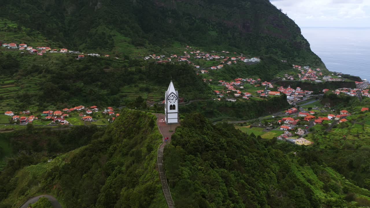 The Nossa Senhora de Fátima Chapel surrounded by lush greenery and mountainous terrain. Aerial Orbit Motion