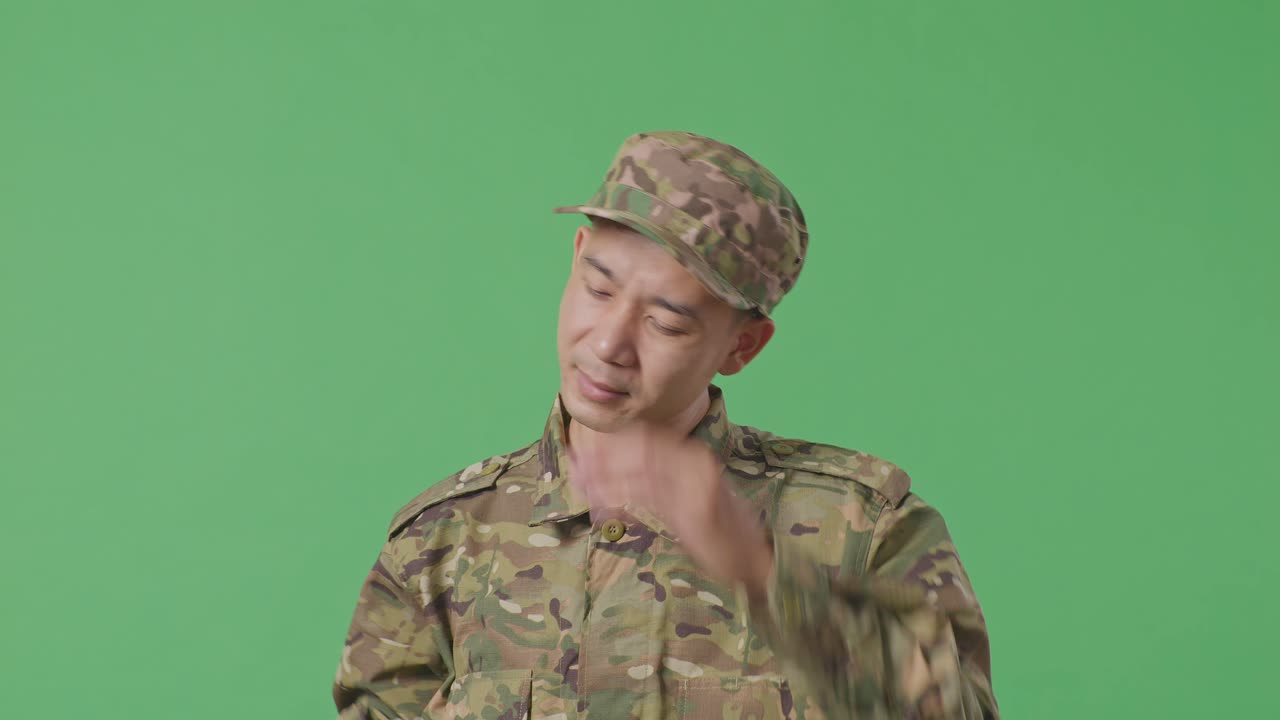 Close Up Of Asian Man Soldier Wiping The Sweat And Being Tired While Standing In The Green Screen Background Studio