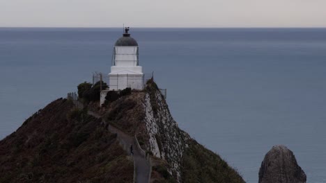 un día nublado en nueva zelanda con un faro en la cresta