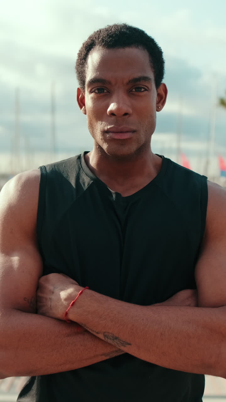 Confident Black Athlete at Harbor with Crossed Arms