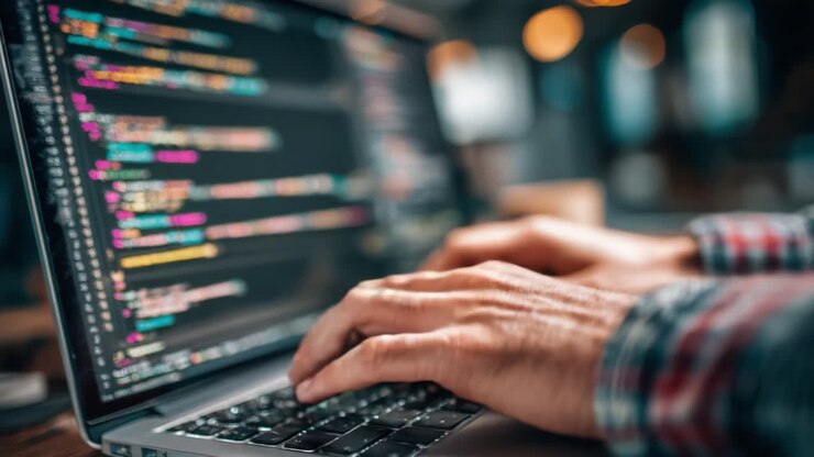 Immersione nel codice: un primo piano di mani che digitano su un laptop, che riflette la passione della programmazione e del mondo digitale