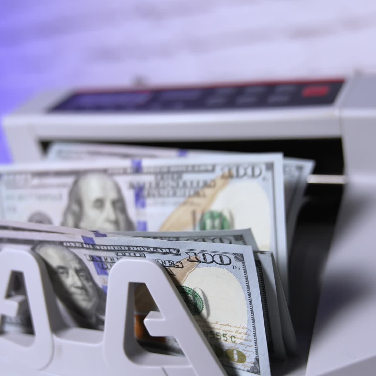 Electronic machine counting hundred dollar bills. Modern automatic equipment for counting paper currency. Money counting machine for banking and commercial activity. Slow motion