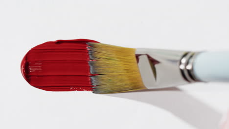 close-up of a paintbrush with red paint