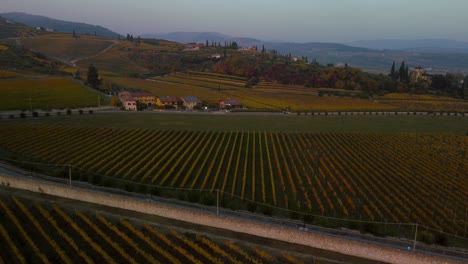 pintorescos campos de viñedos amarillos y verdes en las colinas de valpolicella, verona, italia en otoño después de la cosecha de uvas para vino tinto al atardecer rodeado de granjas tradicionales