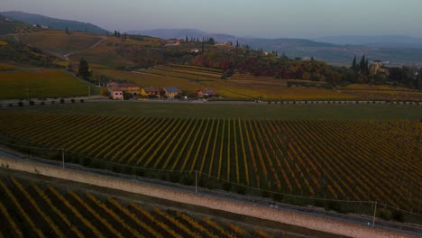 scenic yellow and green vineyard fields on hills in valpolicella, verona, italy in autumn after harvest of grapes for red wine by sunset surrounded by traditional farms