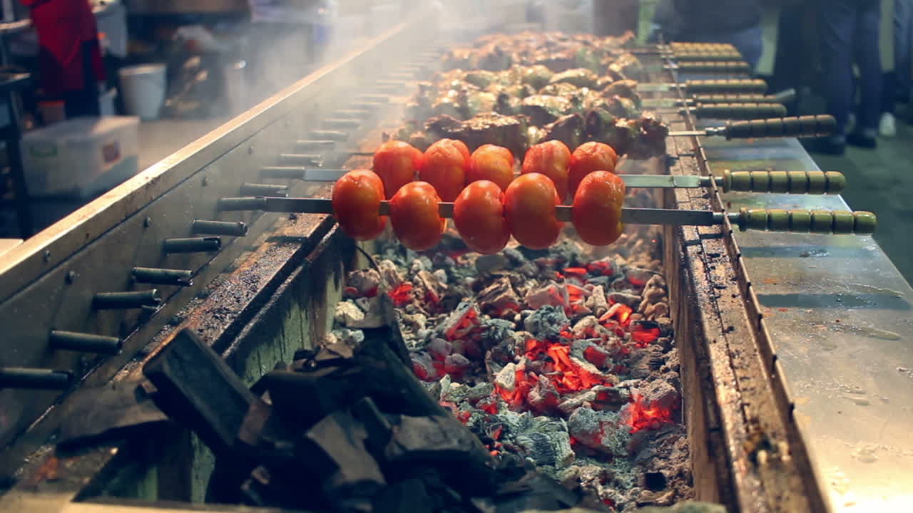 Pomodoro e carne alla griglia su spiedini. Grande mangal a un festival di street food