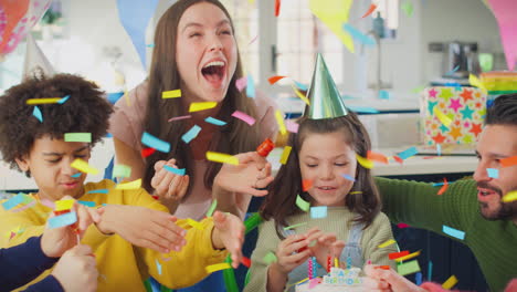 chica con padres y amigos disparando poppers de fiesta en casa para celebrar el cumpleaños